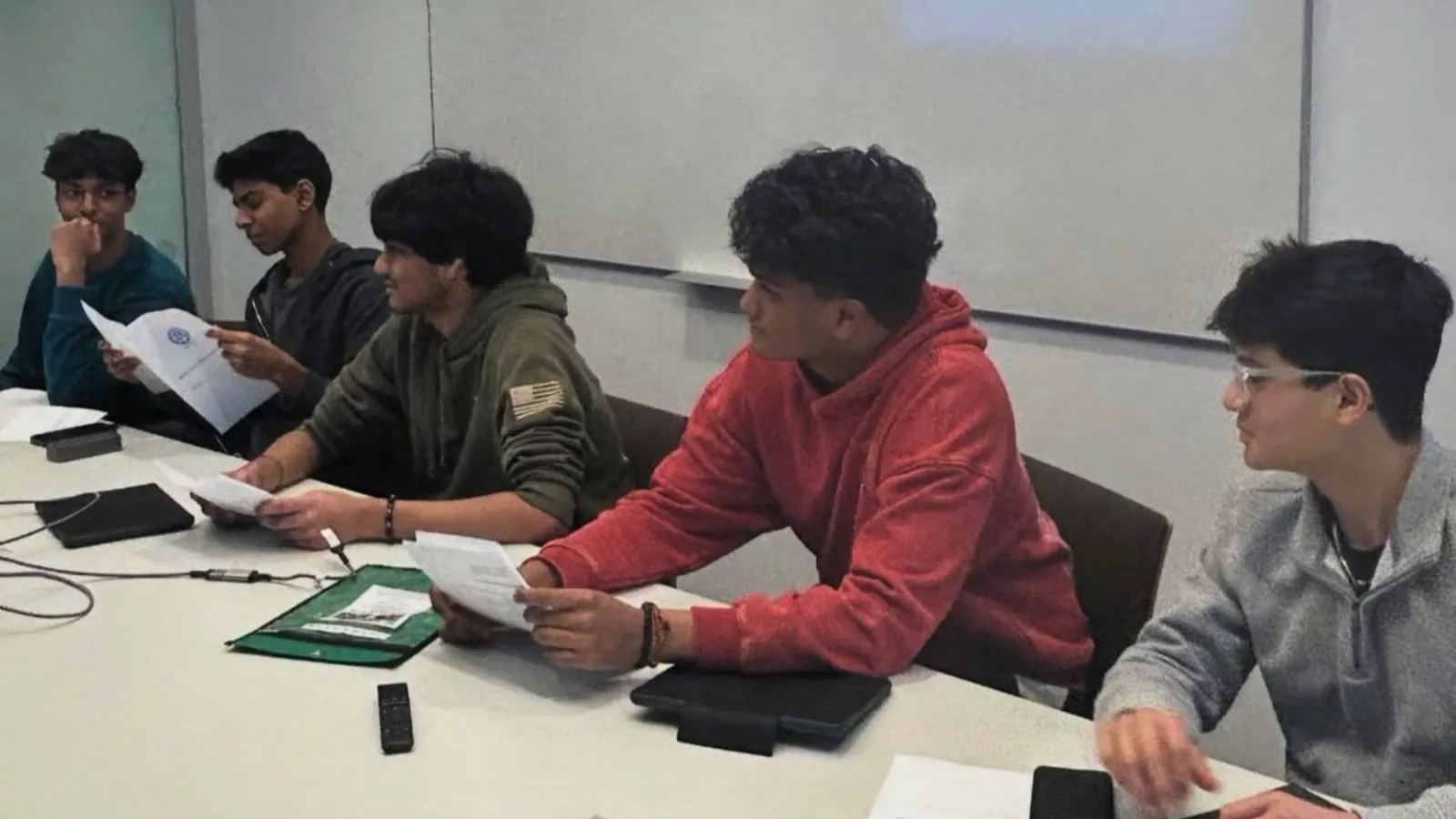 Students seated around a table reading handouts during the Intro to NumPy workshop.